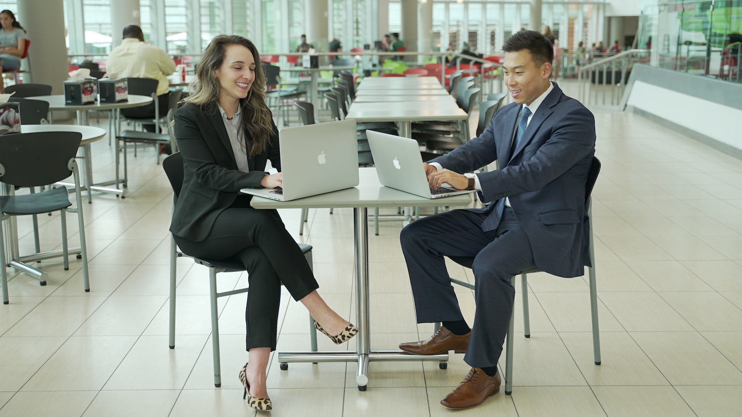 Students working on their laptops in professional attire in Tally.