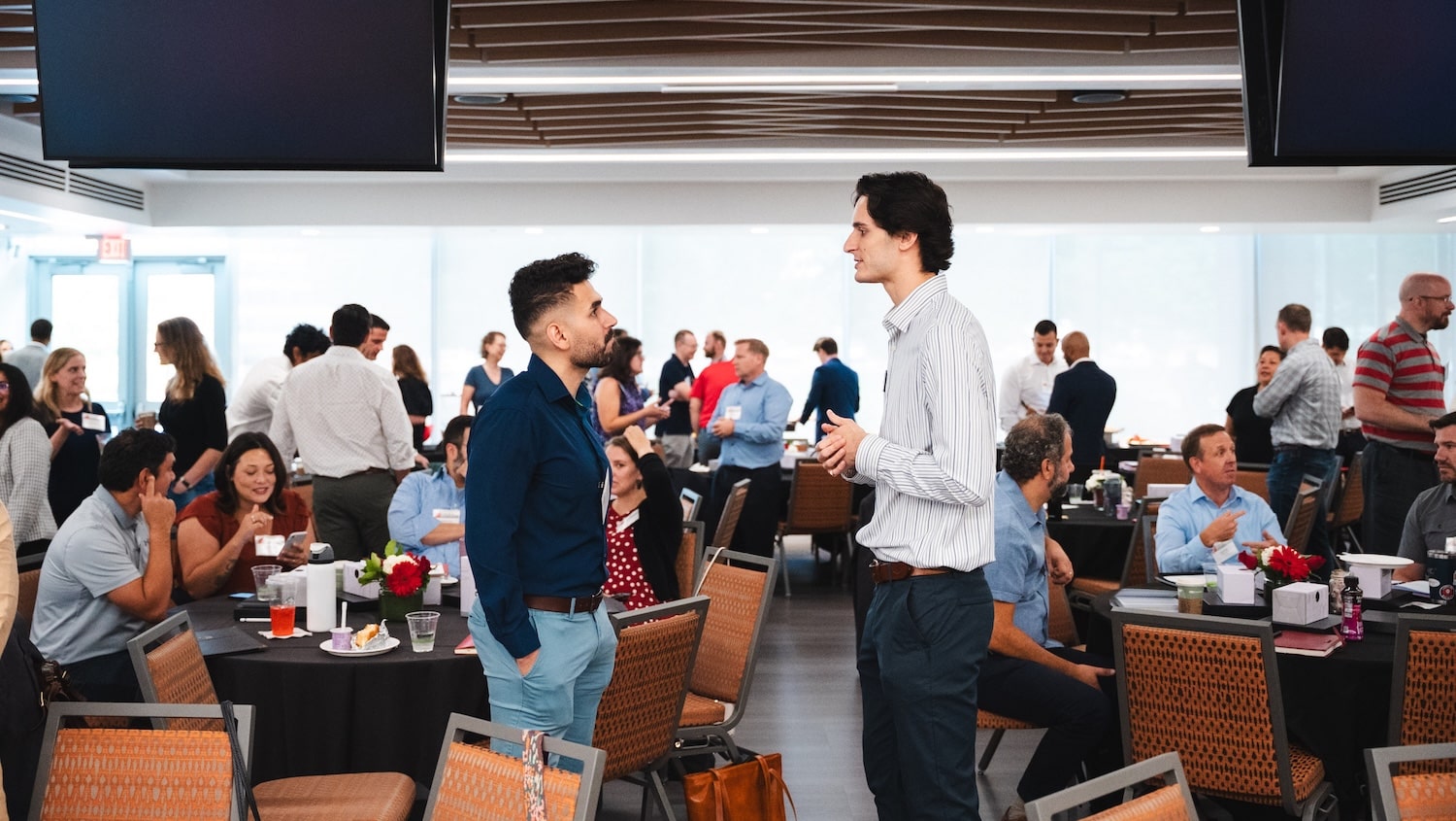 two Jenkins alumni having a conversation among a group of people.